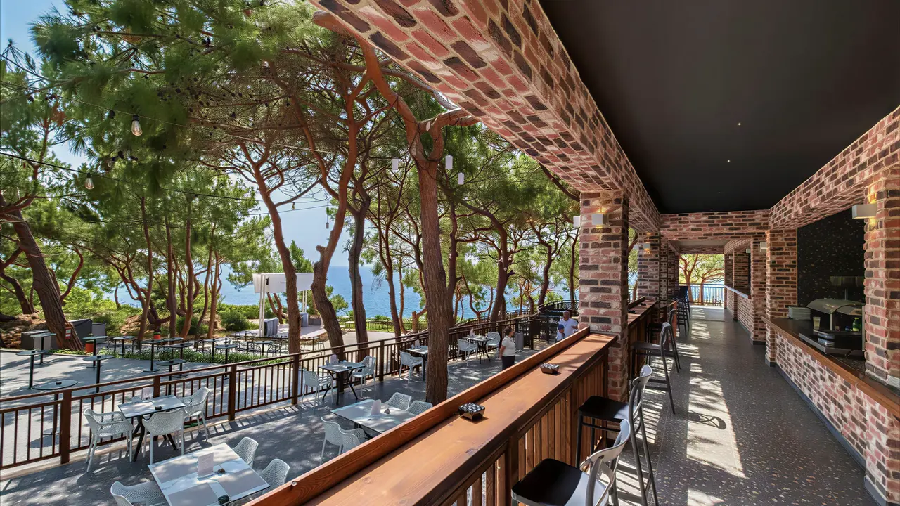 Taras restauracyjny w A Good Life Utopia Family Resort z widokiem na drzewa