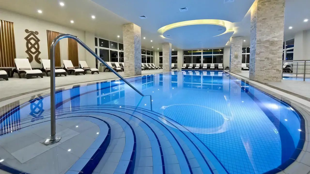 Kryty basen w Acapulco Resort (Kyrenia) z leżakami