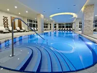 Kryty basen w Acapulco Resort (Kyrenia) z leżakami