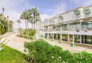 Elewacja budynku Agadir Beach Club z palmami i roślinnością