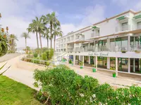 Elewacja budynku Agadir Beach Club z palmami i roślinnością