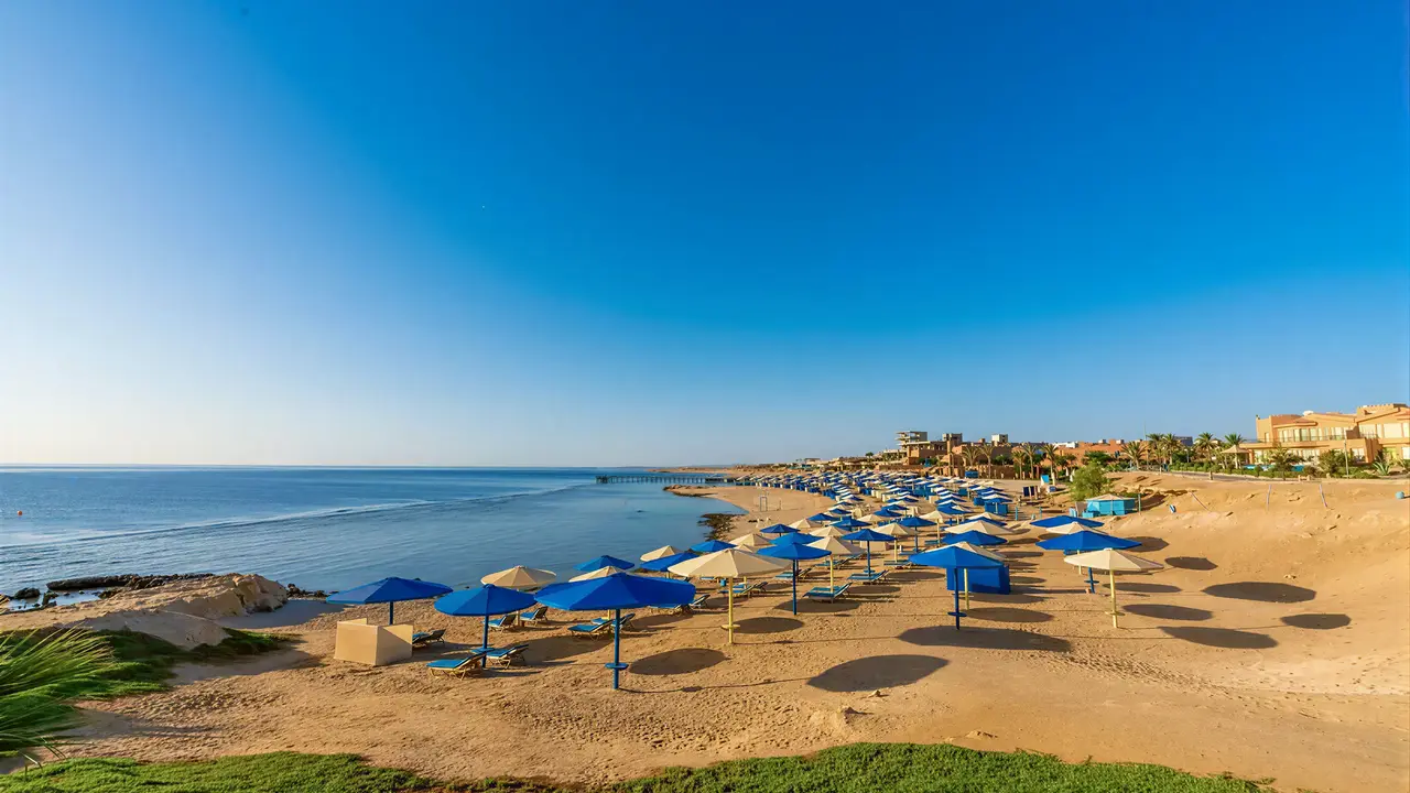 Plaża z niebieskimi parasolami w Akassia Swiss Resort