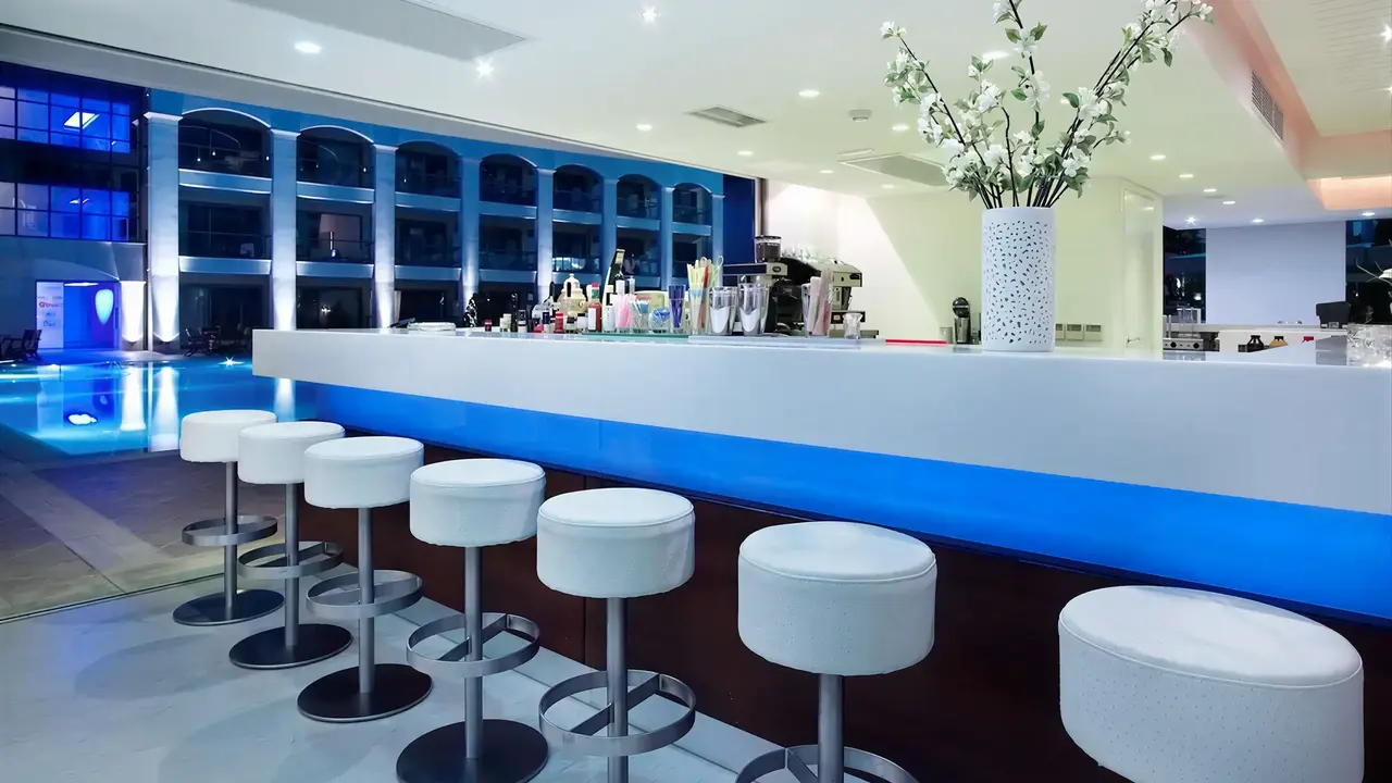 Nowoczesny bar w Albatros Spa Resort z białymi hokerami