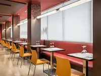 Restauracja z pomarańczowymi krzesłami w Alegria Plaza Paris 