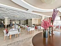 Jasna restauracja z nakrytymi stołami w Altinkaya Resort