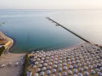 Plaża z parasolami i pomostem w AMC Royal Hotel & Spa 