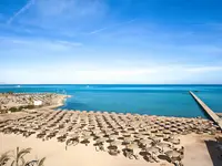 Plaża z parasolami w AMC Royal Hotel & Spa