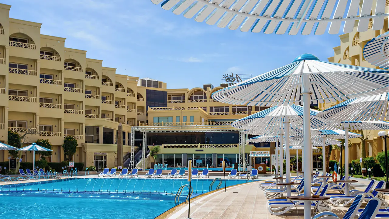Basen z leżakami i parasolami w AMC Royal Hotel & Spa
