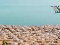 Plaża z parasolami w AMC Royal Hotel & Spa
