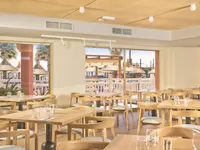 Jadalnia w hotelu Aparthotel Sunset Beach Club z drewnianymi stołami