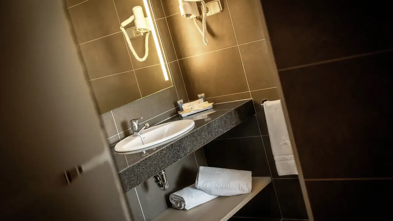 Łazienka w Aqua Aquamarina z umywalką i ręcznikami