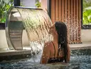Kobieta pod wodospadami w strefie spa Aqua The Breeze
