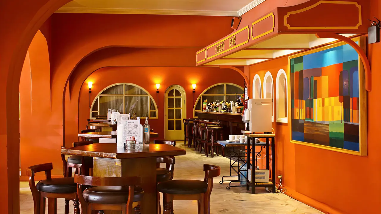 Pomarańczowy bar z wysokimi stolikami w Arabia Azur