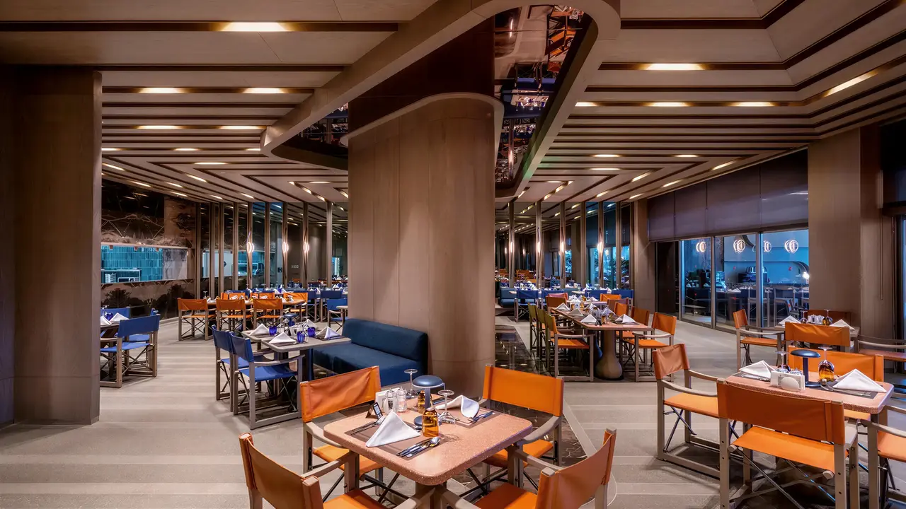 Restauracja w hotelu Arycanda Kirman Premium z pomarańczowymi krzesłami