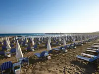 Leżaki i parasole na plaży w Astir Beach