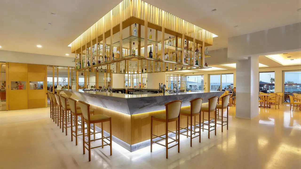Nowoczesny bar z wysokimi hokerami w Astir Beach