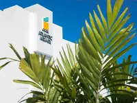 Biała fasada budynku Atlantic Mirage Suites & Spa i palmy