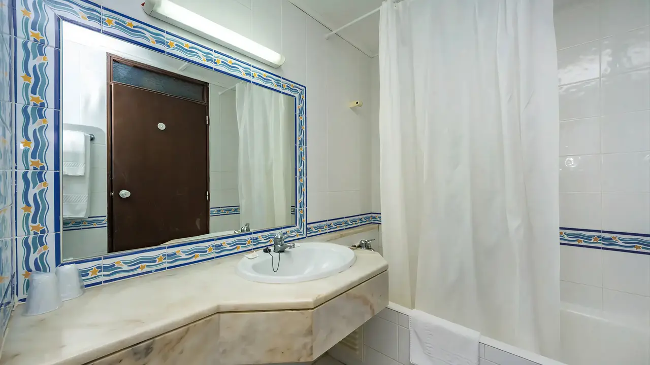 Łazienka w hotelu Auramar Beach Resort z wanną i umywalką