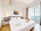Jasna sypialnia z dużym łóżkiem w AX Sunny Coast Resort & Spa