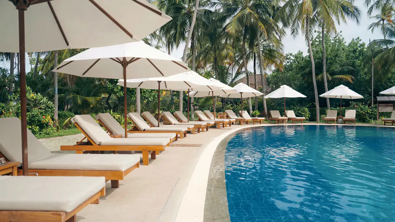 Basen i leżaki z parasolami w Bandos Maldives