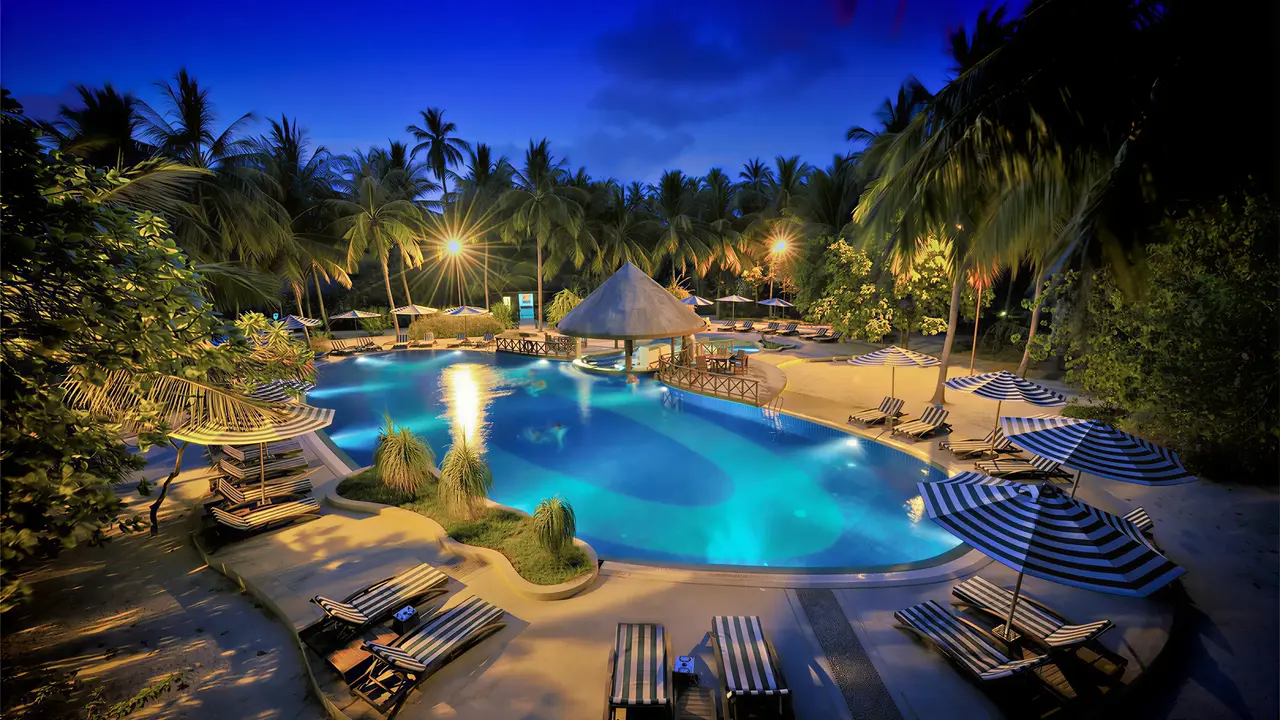 Podświetlony basen z leżakami w Bandos Maldives