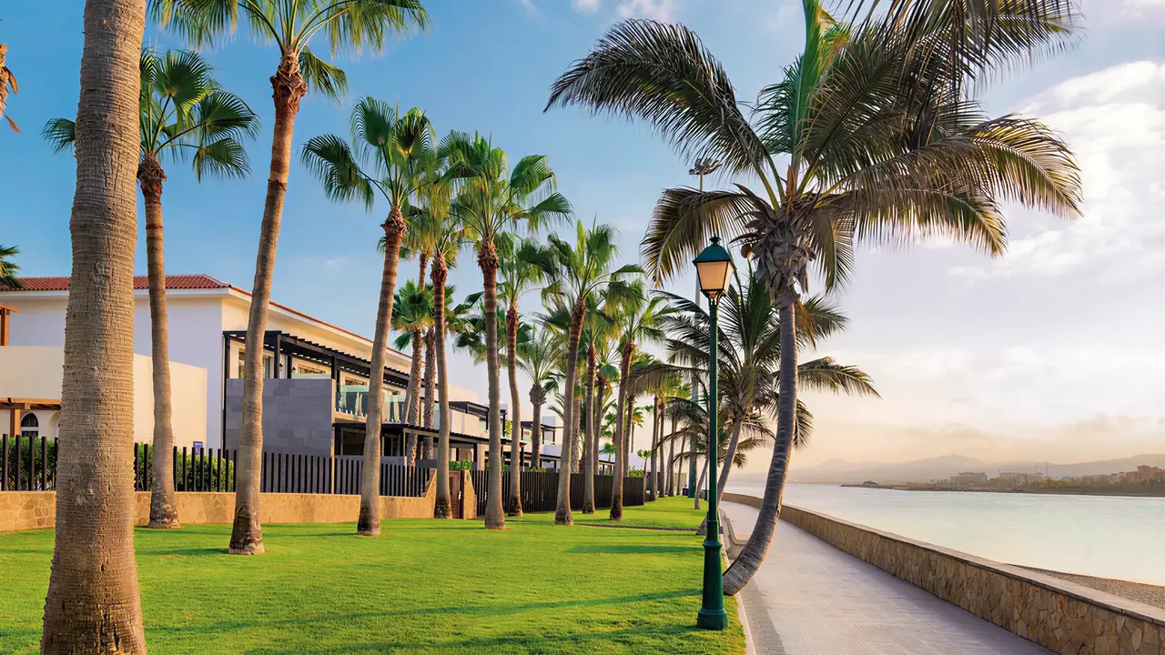 Elewacja budynku Barcelo Fuerteventura Castillo z palmami i chodnikiem