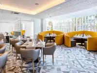Jasna restauracja w Best Tenerife z żółtymi kanapami