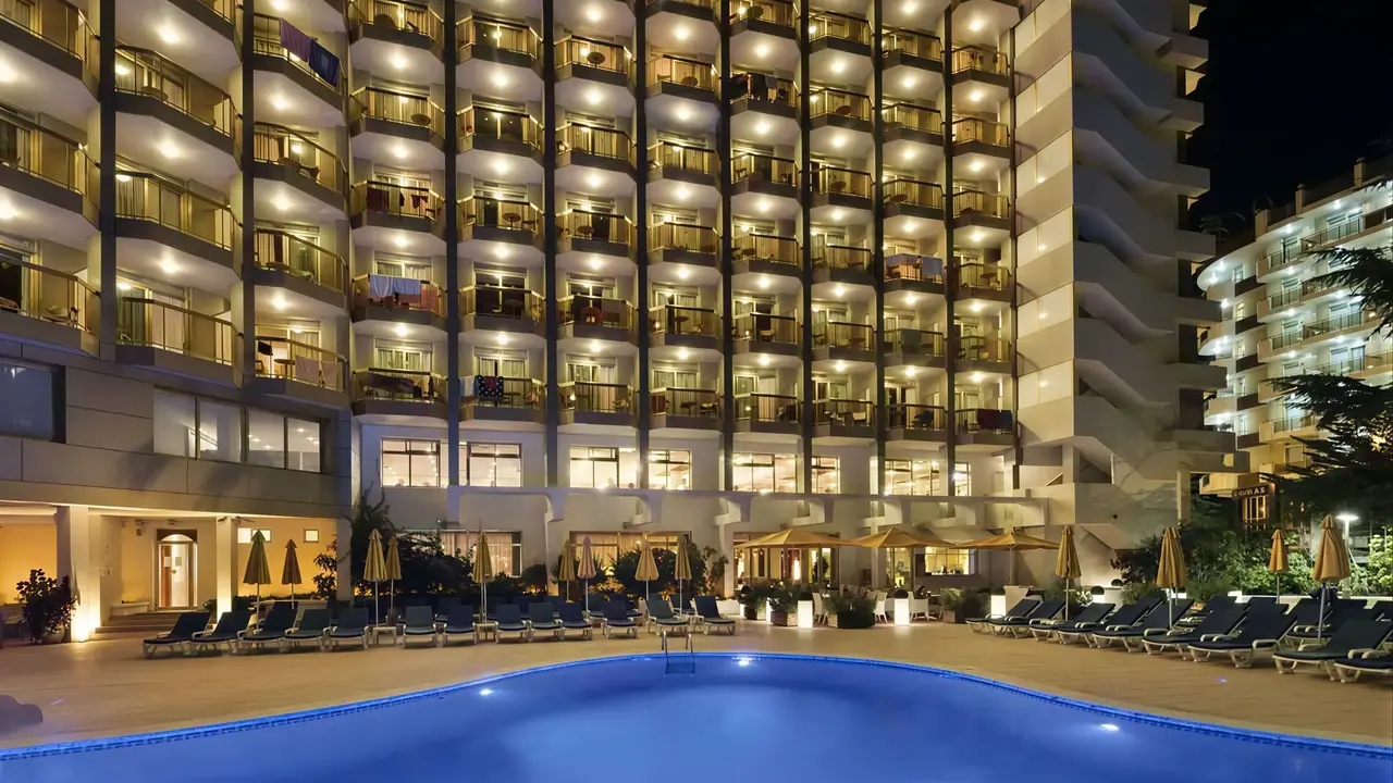 Basen i leżaki w hotelu Beverly Park nocą