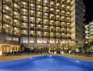 Basen i leżaki w hotelu Beverly Park nocą