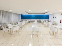 Jasna restauracja w Blue Sea Interpalace z białymi stolikami