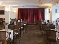 Sala z czerwoną kurtyną i sceną w Bluebay Banus