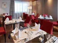 Elegancka restauracja w Bristol (Adelboden) z czerwonymi krzesłami