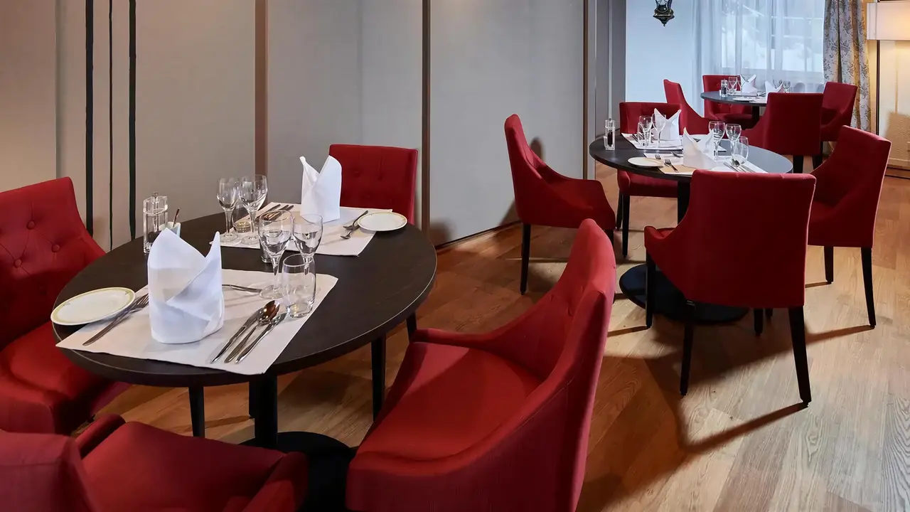 Elegancka restauracja w Bristol (Adelboden) z czerwonymi krzesłami