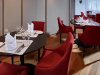 Elegancka restauracja w Bristol (Adelboden) z czerwonymi krzesłami