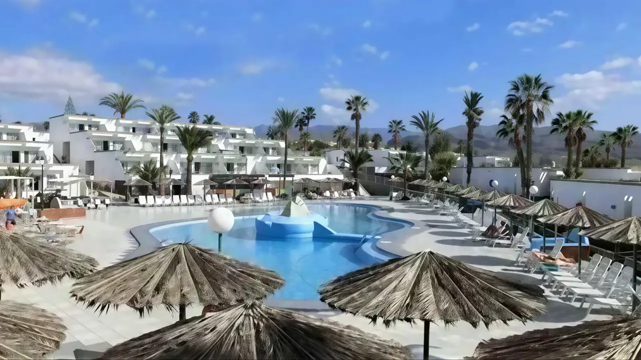 Basen z leżakami i parasolami w Bungalows Vista Oasis