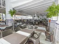 Restauracja w Bungalows Vista Oasis z ustawionymi stolikami
