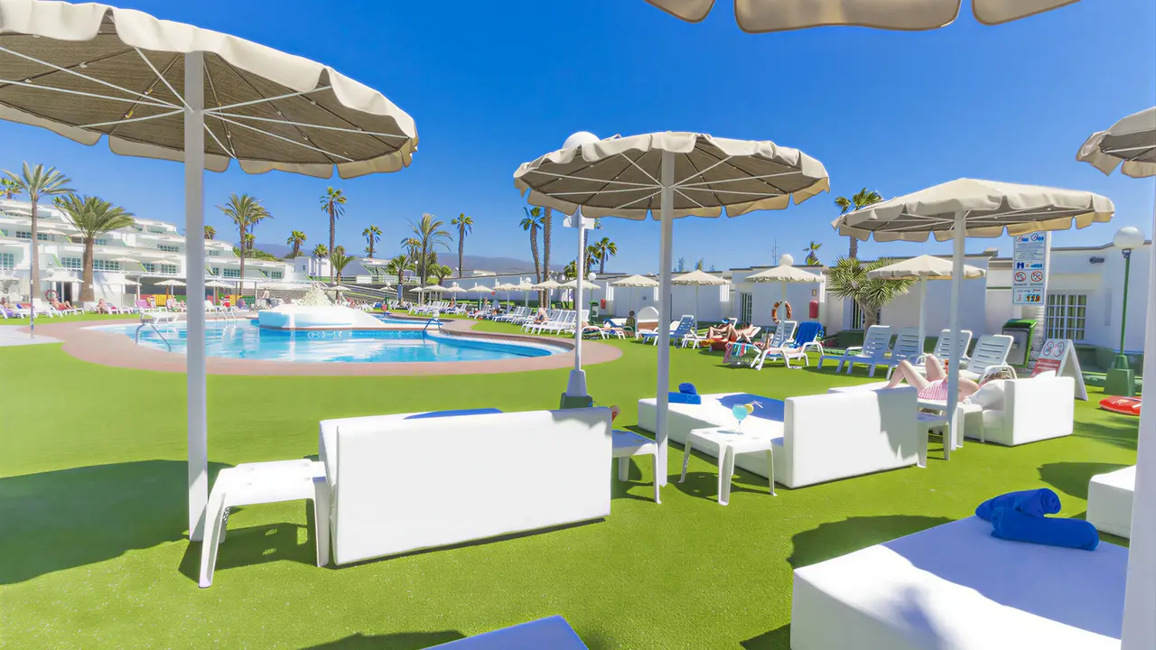 Basen i białe meble wypoczynkowe w Bungalows Vista Oasis