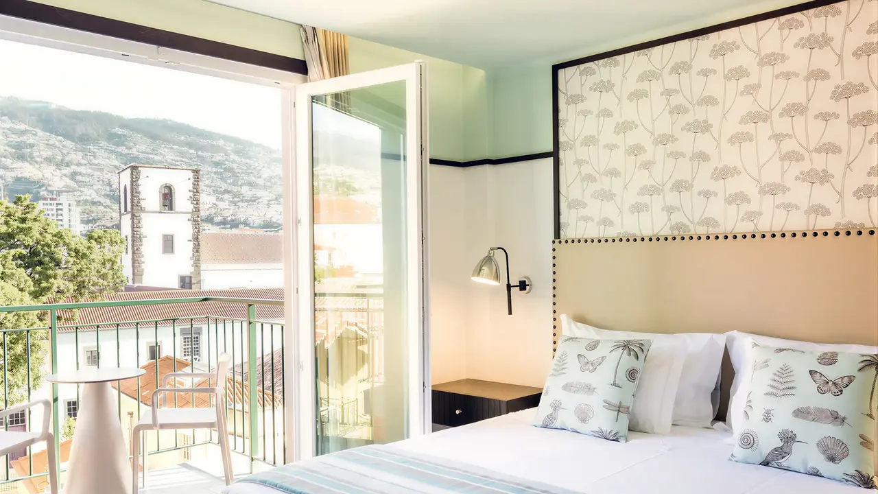Sypialnia z widokiem na balkon w Castanheiro Boutique