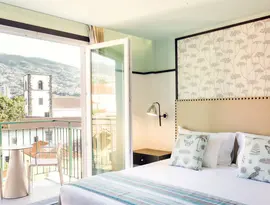 Sypialnia z widokiem na balkon w Castanheiro Boutique