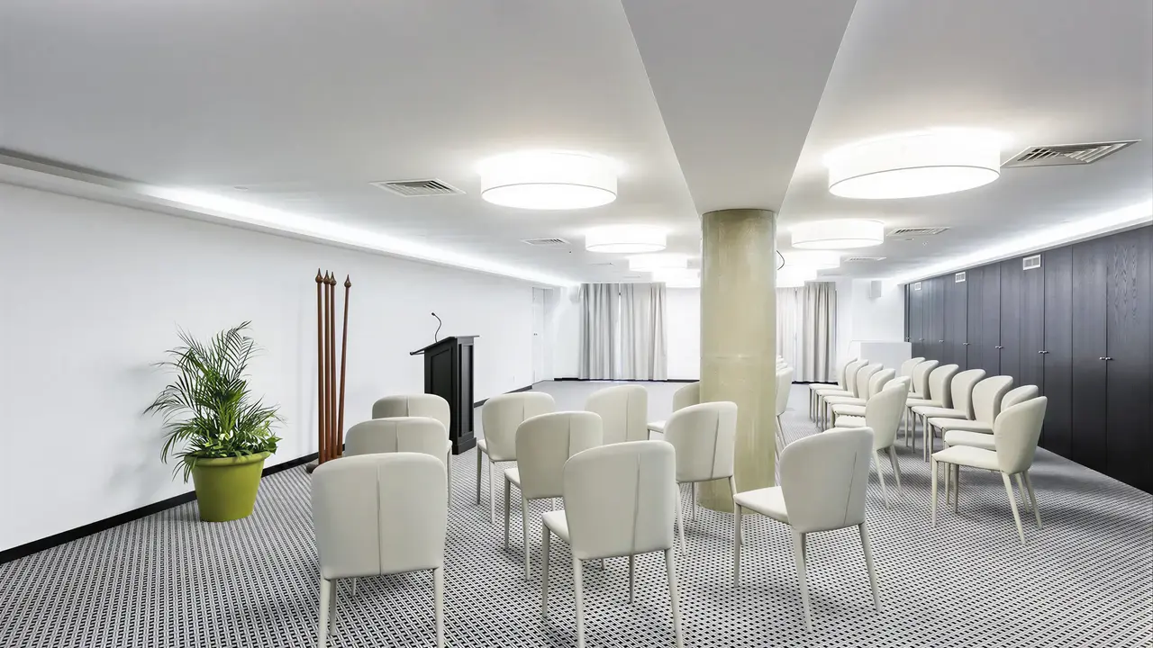 Sala konferencyjna w Castanheiro Boutique z białymi krzesłami