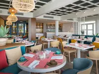 Restauracja w Catalonia Grand Costa Mujeres z nakrytymi do posiłku stolikami
