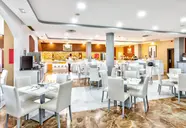 Jadalnia z białymi stołami w Chatur Playa Real Resort