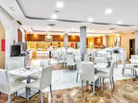Jadalnia z białymi stołami w Chatur Playa Real Resort
