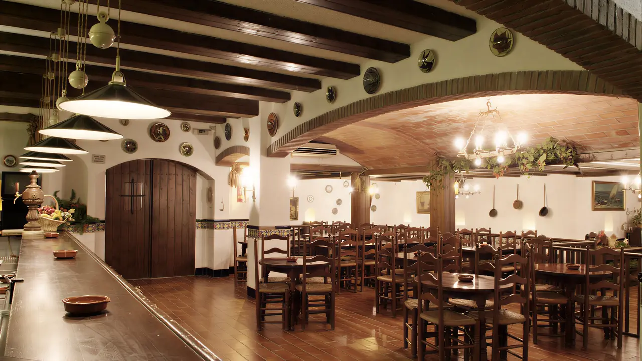 Restauracja w Checkin Garbi z drewnianymi stołami i krzesłami