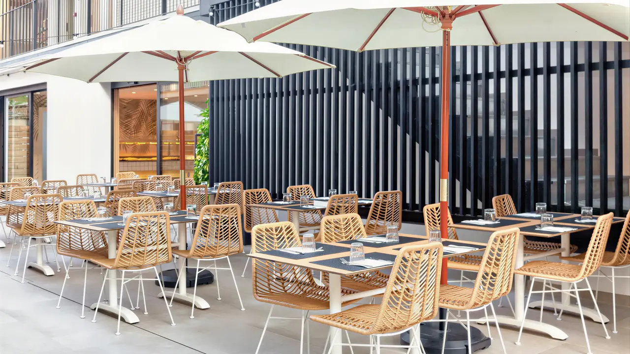 Stoliki w restauracji na zewnątrz w Checkin Garbi