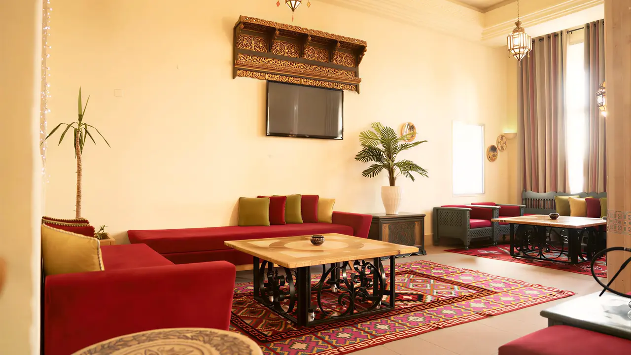 Wnętrze salonu z czerwonymi sofami w Club Calimera Yati Beach