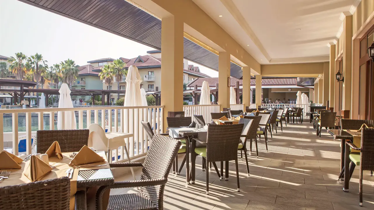 Taras restauracyjny w Club Grand Aqua z ustawionymi stolikami