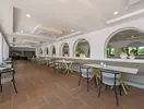 Jadalnia w Club Turan Prince World z białymi stołami i krzesłami