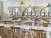 Jasna jadalnia z drewnianymi stołami w Coral Teide Mar