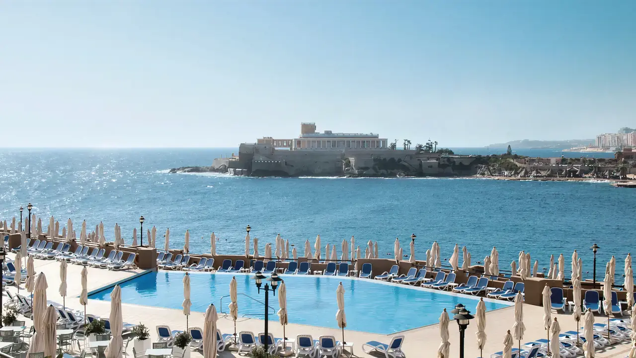 Basen z leżakami w Corinthia St. George's Bay nad morzem